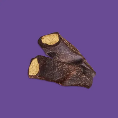 Dos snacks masticables marrones con relleno claro, aptos como golosina para mascotas.
