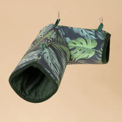 Túnel de tela verde con estampado de hojas tropicales, dos aberturas y ganchos para fijación.