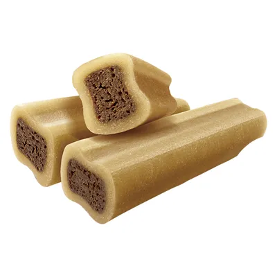 Trzy jasnobrązowe przysmaki dla psa z ciemniejszym nadzieniem w środku, przekrój pokazuje dwuwarstwową strukturę produktu.