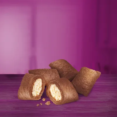 Nahaufnahme von braunen Snacks mit knuspriger Hülle und heller Füllung, auf violettem Hintergrund präsentiert.