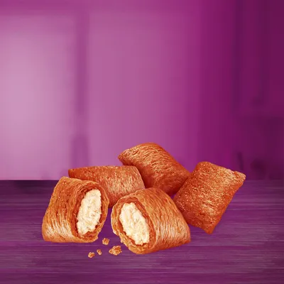Knusprige Snacks mit goldbrauner Hülle und cremiger Füllung, auf lila Hintergrund präsentiert.