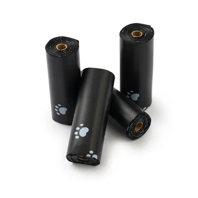 Four black rolls with dog paw design, likely waste bags or poop bags for pets.