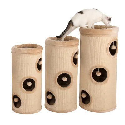 Three beige cylindrical scratching towers with multiple entry holes and hanging toys, shown in different heights. A cat is standing on the tallest tower.