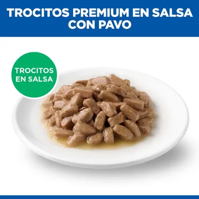 Trocitos Premium en salsa con pavo, servidos en un plato blanco. Círculo verde con texto: Trocitos en salsa. Trocitos Premium en salsa con pavo, servidos en un plato blanco. Círculo verde con texto: Trocitos en salsa.
