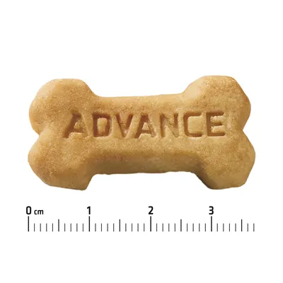 Piškot v obliki kosti z napisom ADVANCE, pod njim merilo v centimetrih od 0 do 4 cm.