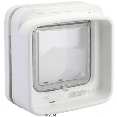 Chatière blanche en plastique avec porte transparente et bouton rotatif, marque SUREFLAP visible sur le bas du cadre.