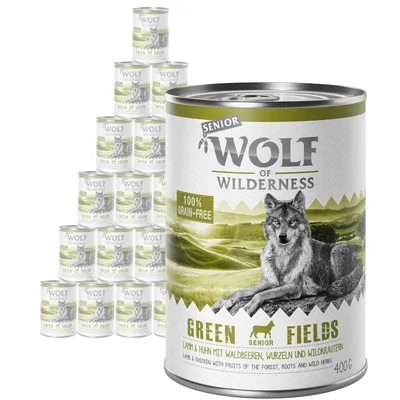 Wolf of Wilderness Senior Green Fields 400g tin, visible text: 100% grain-free, lamb & chicken with fruits of the forest, roots and wild herbs. Multiple tins shown in background.