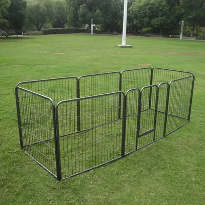 Kovový výbeh s mrežovými stenami a dverami, obdĺžnikový tvar, postavený na zelenej lúke.