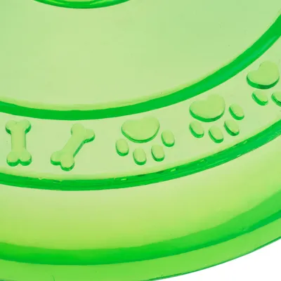 Grøn frisbee af plast med præget knogle-, hjerte- og pote-motiver på overfladen.