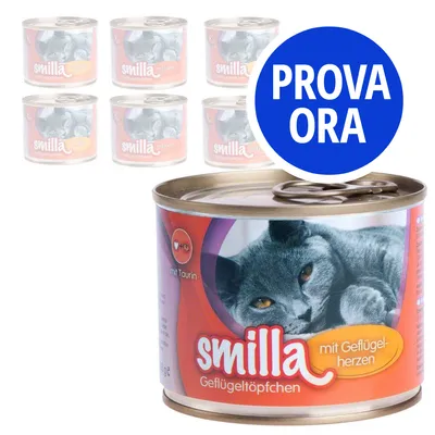 6 lattine di cibo per gatti Smilla Geflügeltöpfchen, visibile scritta 'mit Geflügelherzen', 'mit Taurin' e bollino blu con testo 'PROVA ORA'. Etichetta con gatto grigio.