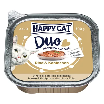 HAPPY CAT Duo Häppchen auf Paté, Rind & Kaninchen, 100 g. + Vitamine + Kräuter. Strato di paté con bocconcini Manzo & Coniglio. Billede af kat og skål med foder synlig.