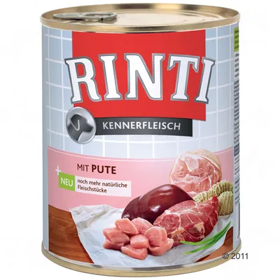 Lata de comida para perros Rinti Kennerfleisch, texto visible: 'MIT PUTE', 'NEU noch mehr natürliche Fleischstücke', imágenes de trozos de carne cruda en la etiqueta.