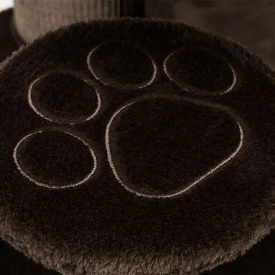 Superfície de tecido castanho com relevo em forma de pegada de animal. Material felpudo visível.