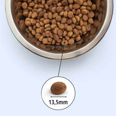 Metallschüssel mit braunen Kroketten, Detailansicht einer Krokette mit Größenangabe 13,5 mm. Metallschüssel mit braunen Kroketten, Detailansicht einer Krokette mit Größenangabe 13,5 mm.