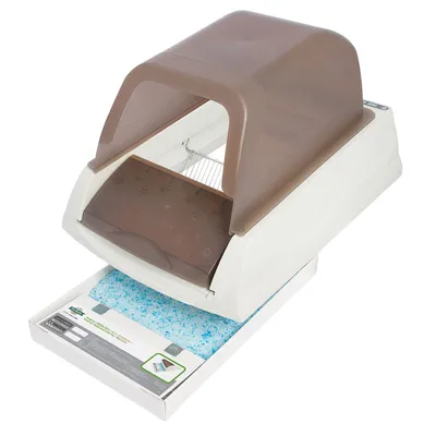 Covered self-cleaning litter box with a pull-out tray containing blue absorbent crystals, showing the waste collection system in use.