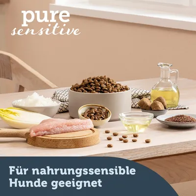 pure sensitive. Für nahrungssensible Hunde geeignet. Croquettes dans un bol, filet de viande crue, huile, riz, endive, graines et autres ingrédients visibles sur une table.