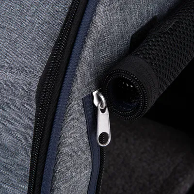 Detailansicht eines grauen Stoffmaterials mit Reissverschluss und schwarzem Netzgriff.