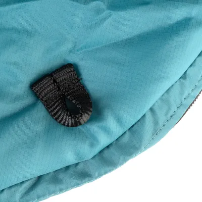 Detailní záběr na černý upevňovací kroužek z odolného materiálu na tyrkysovém textilním povrchu.