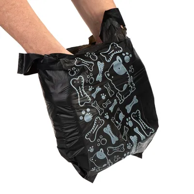 Zwarte plastic zak met lichtblauwe hondenbotjes, pootafdrukken en hondenkoppen, vastgehouden door twee handen. Materiaal: plastic.