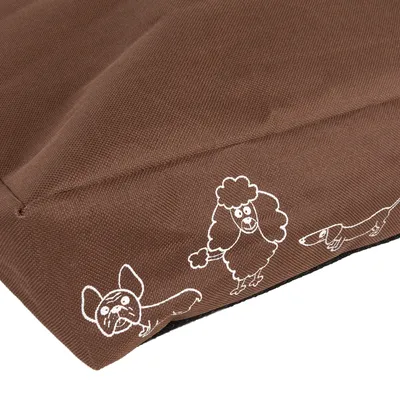 Brązowy materiał z białymi rysunkami psów różnych ras na brzegu. Widoczne faktura tkaniny i szwy.