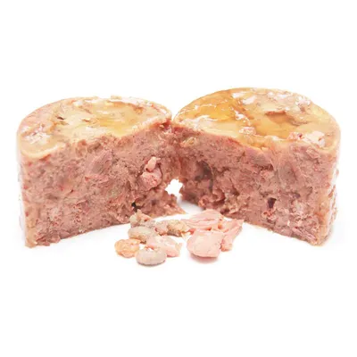 Alimento umido per animali da compagnia, porzione tagliata a metà con consistenza compatta e pezzi visibili di carne su sfondo bianco.