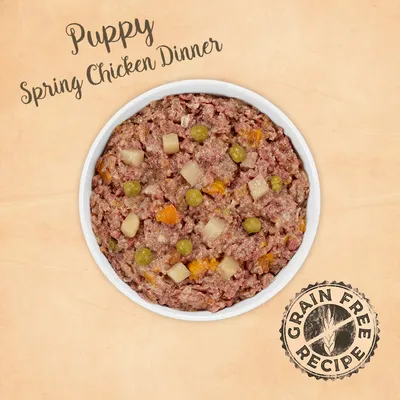 Puppy Spring Chicken Dinner -koiran märkäruoka, viljaton resepti. Näkyvissä herneitä ja kuutioituja vihanneksia ruoka-annoksessa valkoisessa kulhossa.