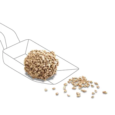 Abbildung von Streu in einer Schaufel, lose Körner daneben. Zeigt die Konsistenz des Produkts.