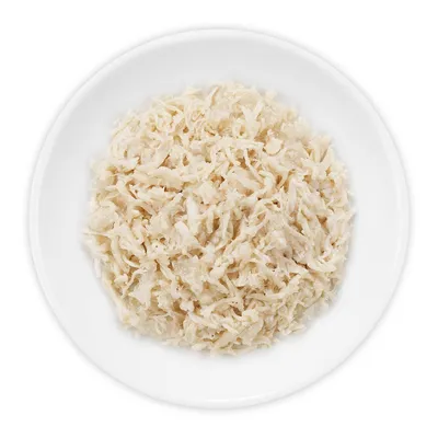 Wit vlees in reepjes geserveerd op een wit bord, zonder zichtbare verpakking of merknaam.