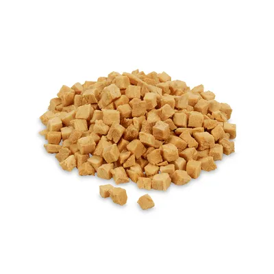 Cubi di snack per pet, colore beige chiaro, disposti in un mucchio su sfondo bianco. Nessun marchio o testo visibile.