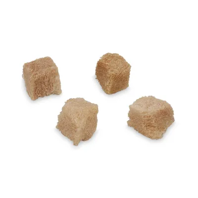 Quattro cubetti marroni di snack per animali su sfondo bianco, senza confezione o marchio visibile.