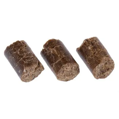 Trois friandises cylindriques brunes pour animaux, sans emballage ni marque visible, posées sur fond blanc.
