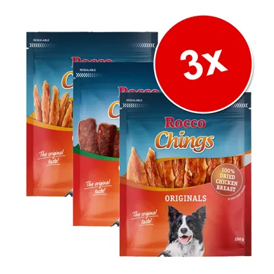 Три упаковки лакомств для собак Rocco Chings Originals, 250 г, надпись на круге: 3x, видны кусочки сушёной куриной грудки и текст '100% dried chicken breast'.