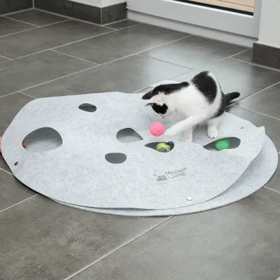 Spielmatte aus Filz mit Löchern, Marke Modern Living. Katze spielt mit bunten Bällen auf der Matte.