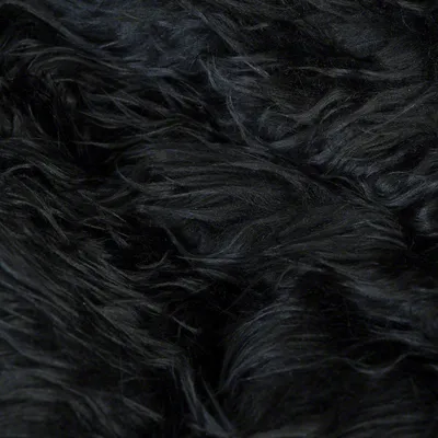 Detailní záběr na černou, dlouhosrstou umělou kožešinu.