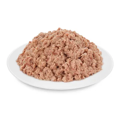 Apróra darált, barna színű nedves állateledel fehér tányéron, csomagolás vagy márkajelzés nélkül látható.