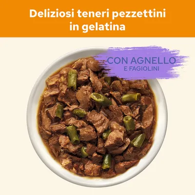 Deliziosi teneri pezzettini in gelatina con agnello e fagiolini, visibili nella ciotola. Testo: 'CON AGNELLO E FAGIOLINI'.