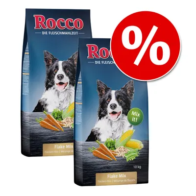Dwie torby Rocco Flake Mix 10 kg z wizerunkiem psa, marchewką, kukurydzą i groszkiem na opakowaniu; widoczny czerwony symbol procentu oznaczający promocję.