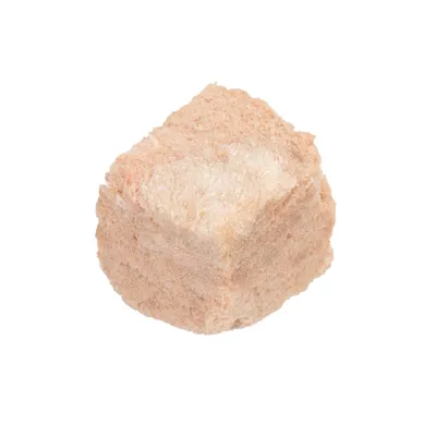 En ljusbeige, kubformad bit frystorkat kött på vit bakgrund. Ingen synlig förpackning eller märkning.