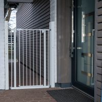 Porta di sicurezza in metallo bianco, montata tra due pareti, adatta per ingressi o passaggi.