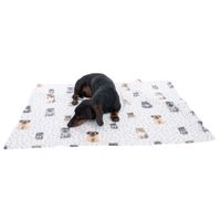 Cane sdraiato su una coperta bianca con motivi di cani e punti grigi.