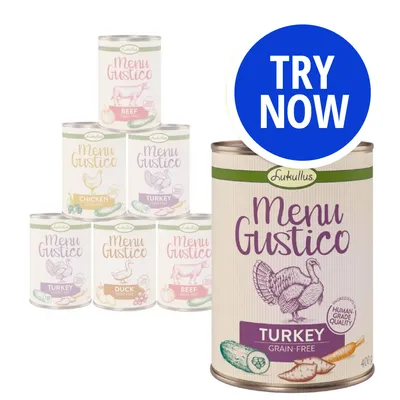 Selection of Menu Gustico tins in beef, chicken, turkey and duck varieties with a large tin labelled turkey grain-free. Blue circle with white text reads 'Try Now'.