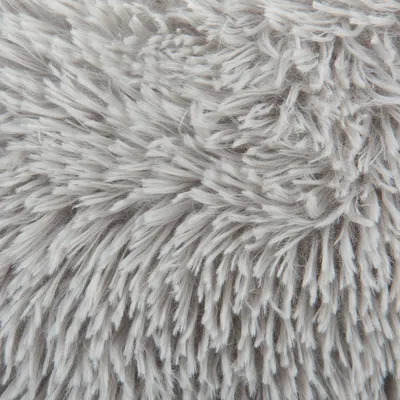 Detailní záběr na šedý, nadýchaný materiál s dlouhými vlákny, vhodný například pro pelíšky nebo deky pro domácí mazlíčky.