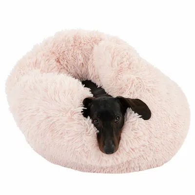Hond ligt in een zacht, roze knuffelbed. Product toont comfort en design van het huisdierenbed.