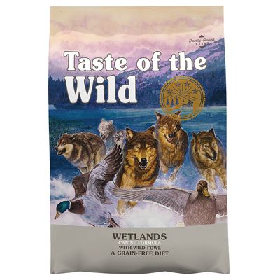 Taste of the Wild Wetlands Canine Formula with Wild Fowl A Grain-Free Diet, förpackning med illustration av vargar och änder. Family-Owned BBAH synligt uppe till höger.