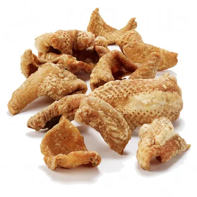 Кусочки сушёной куриной кожи без упаковки, крупным планом на белом фоне. Видна текстура и форма лакомства. Кусочки сушёной куриной кожи без упаковки, крупным планом на белом фоне. Видна текстура и форма лакомства.
