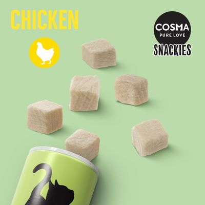 Cosma Pure Love Snackies mit Huhn. Gefriergetrocknete Würfel, gelbes Hühnchen-Symbol und grüne Verpackung mit schwarzer Katzen-Silhouette.