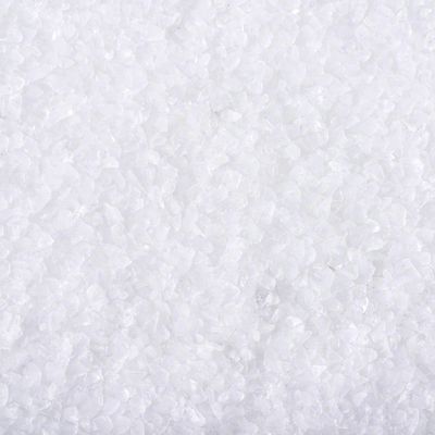 Witte korrelige substantie, close-up van grove kristallen. Materiaal: mogelijk mineraal of steenzout, geen merknaam of tekst zichtbaar.