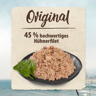 Original. 45 % hochwertiges Hühnerfilet, serviert auf schwarzem Teller mit frischem Spinatblatt.