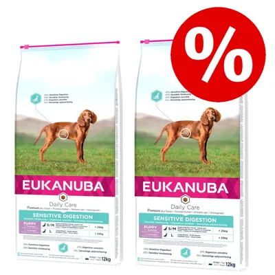 Zwei Säcke Eukanuba Daily Care Sensitive Digestion Puppy Trockenfutter, 12 kg, mit Hundebild und großem Prozentzeichen für Rabattaktion.
