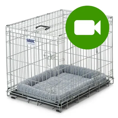 Metalowa klatka Savic z szarą poduszką, widoczne logo marki. Na górze zielona ikona kamery wideo.